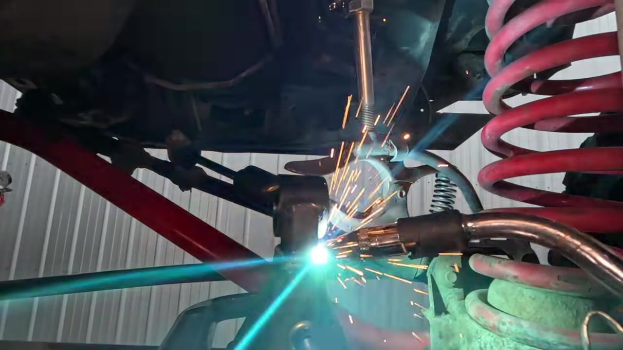 Welding new Johnny Joint cup onto Dana 30 axle bracket with sparks flying