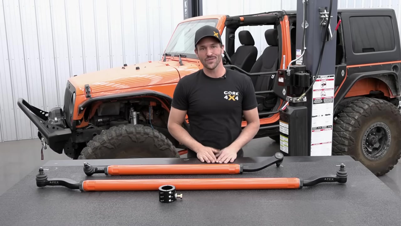 Core 4x4 2.5 ton steering kit for Jeep Wrangler JK laid out on workbench with orange tie rod and drag link