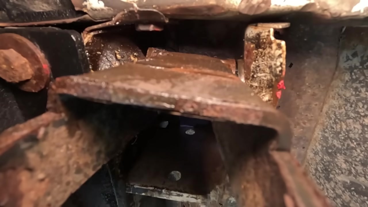 Close-up of severely rusted factory shackle mounting area on a Jeep XJ