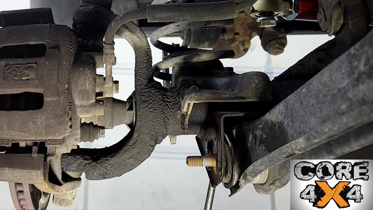 Close-up of rusty seized lower control arm bolt on the TJ front axle