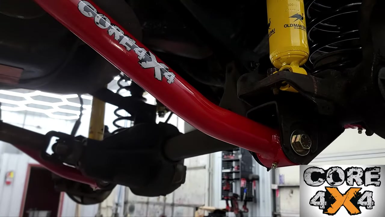 Completed front suspension install showing red Core 4x4 lower control arm with yellow shock and new coil spring