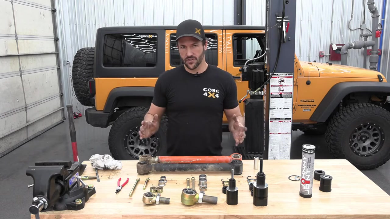 Core 4x4 technician explaining Johnny Joint rebuild methods with parts and tools on workbench