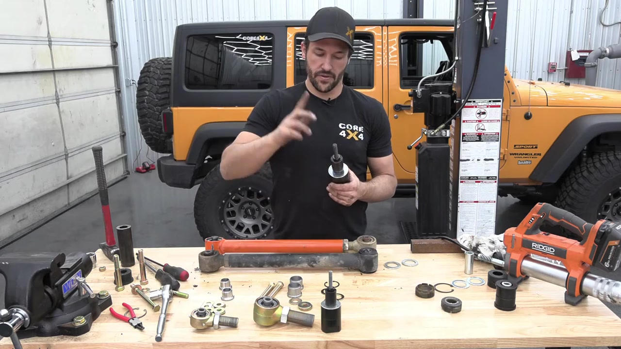 RockJock Johnny Joint clamp tool being used in a vise to rebuild a control arm joint
