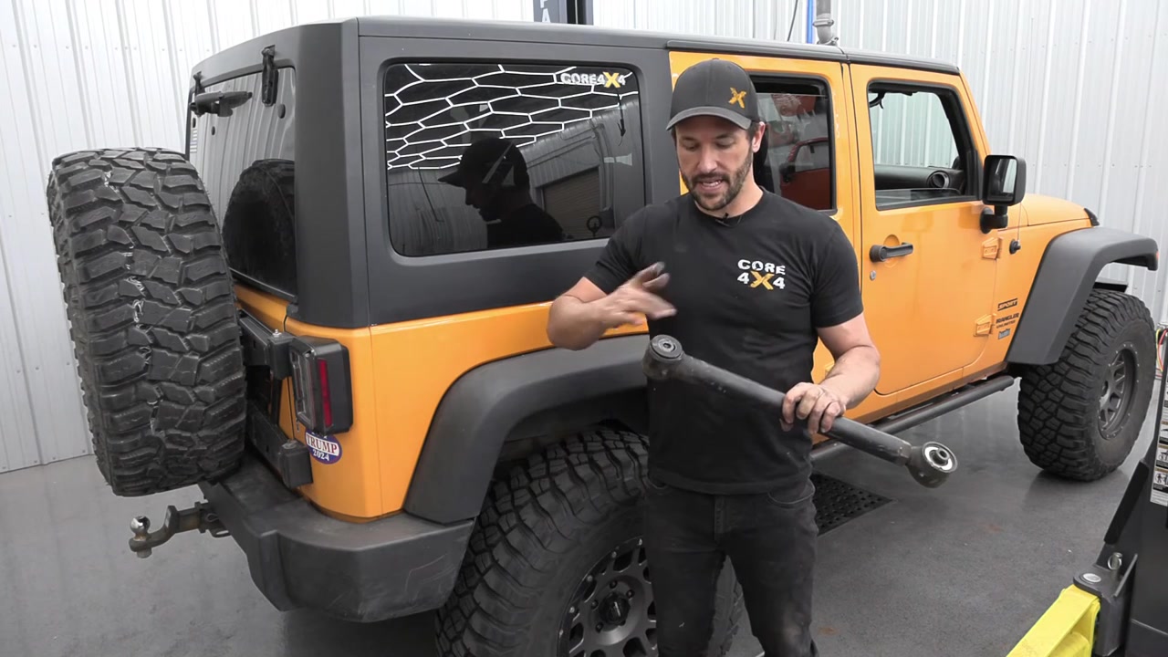 Core 4x4 technician with fully rebuilt control arm ready to reinstall on Jeep JK