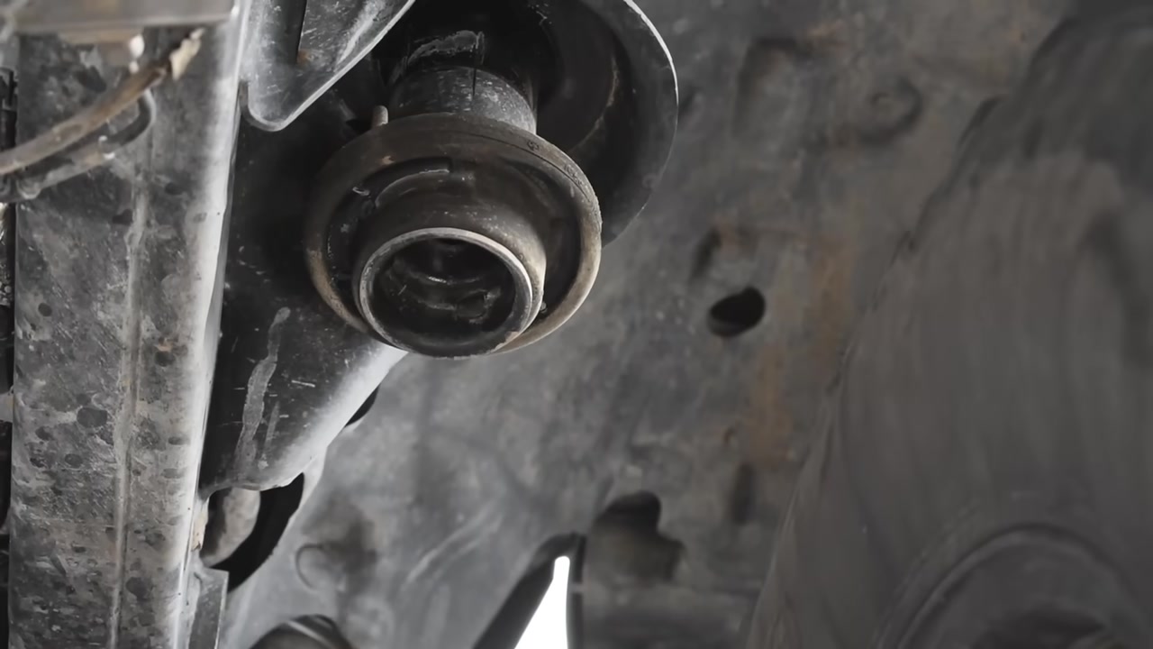 Close-up of factory rubber bushing with fused crush sleeve on a Jeep control arm