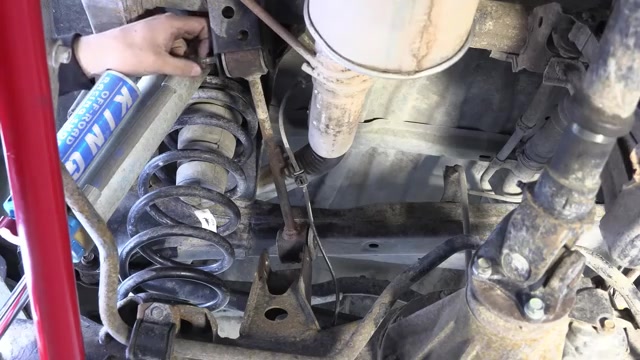 Close-up of the 4Runner rear suspension area showing the coil spring, King shock, and factory mounting points during the control arm install