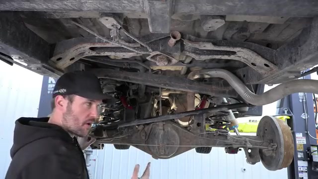 Spence standing under the 4Runner showing the completed rear suspension with new red Core 4x4 Camp Series control arms and track bar installed