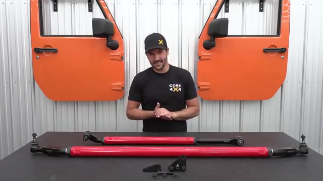 Core 4x4 2.5 ton steering kit for Ram 2500 with red tie rod and drag link laid out on workbench