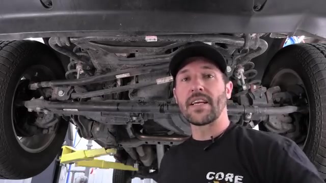 Factory steering visible under Ram 2500 showing tie rod and drag link before removal