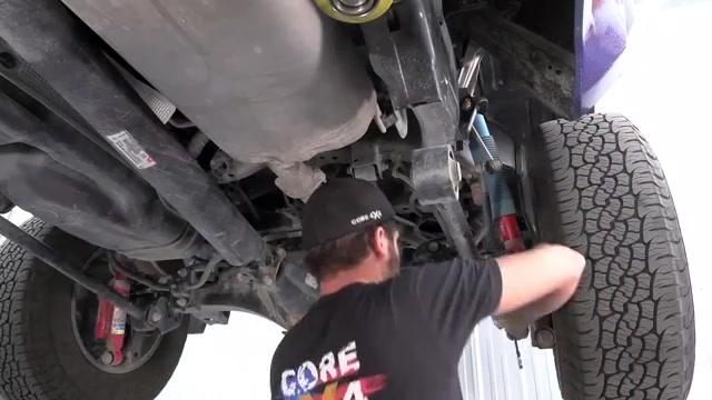 Underneath the 2024 Toyota Tacoma showing the factory rear suspension components before removal