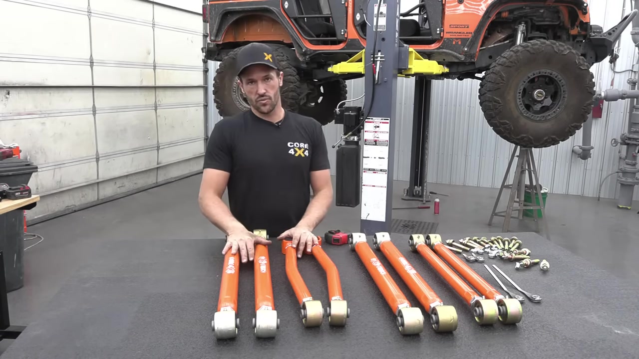 Core 4x4 Crawl Series JK long arm kit laid out on a table showing all eight orange control arms with Johnny Joints and hardware