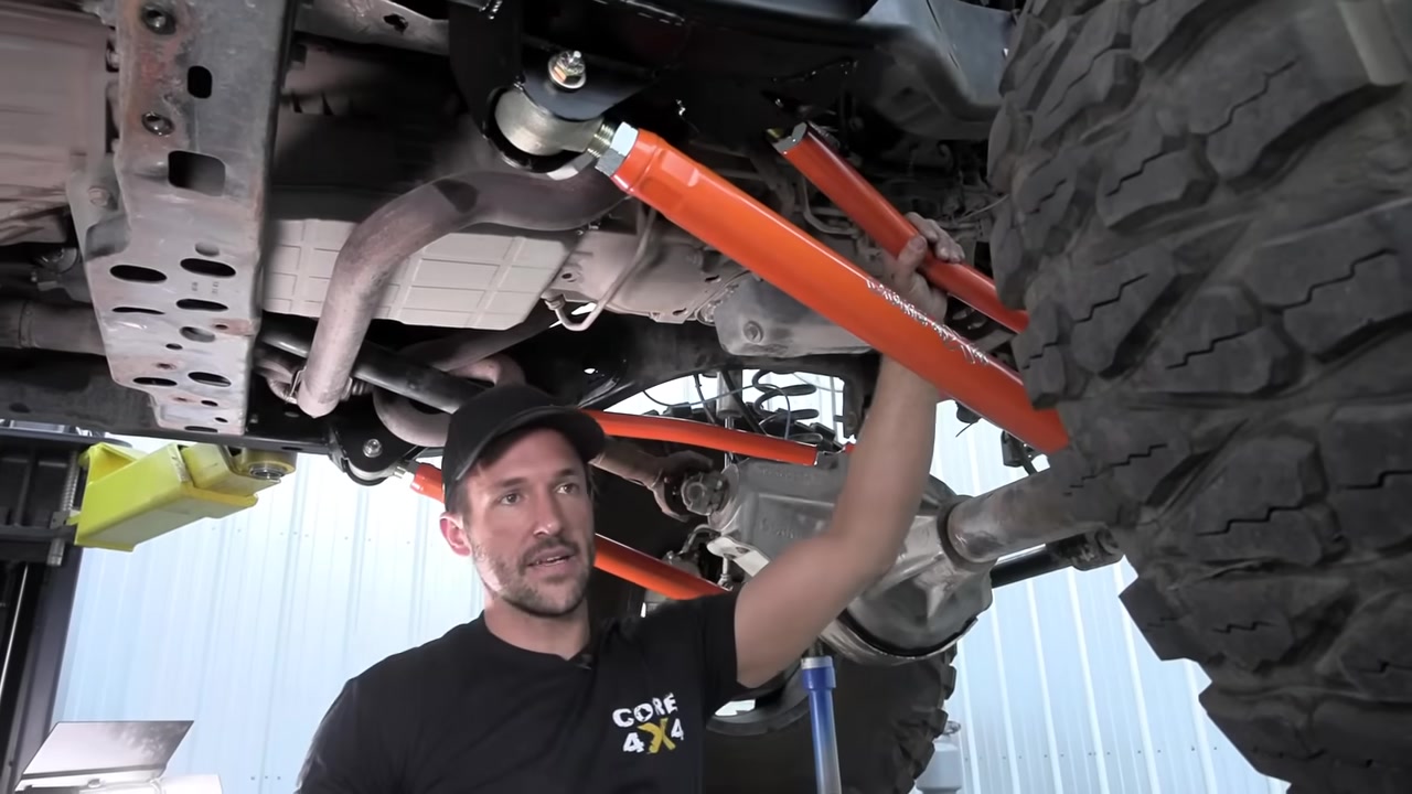 Installing the orange Core 4x4 Crawl Series front control arms on the JK Wrangler with Johnny Joints visible