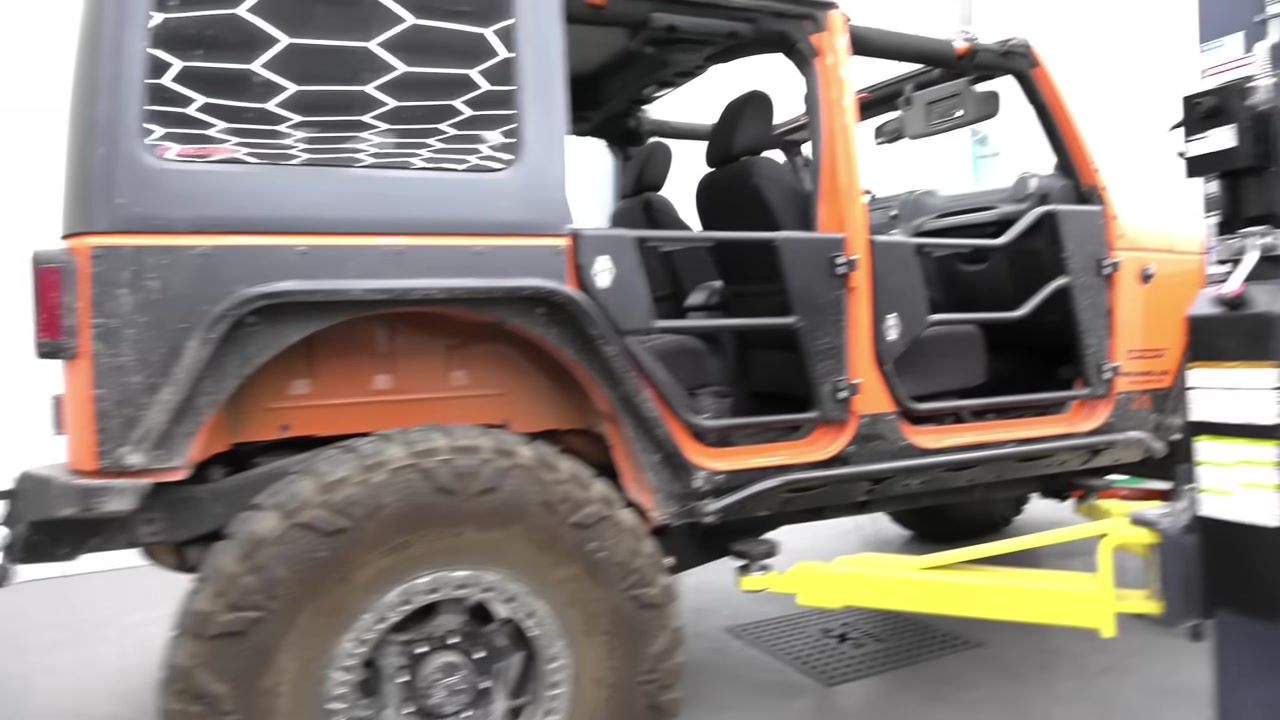 Side view of the completed JK Wrangler on the ground after the long arm install showing the improved stance