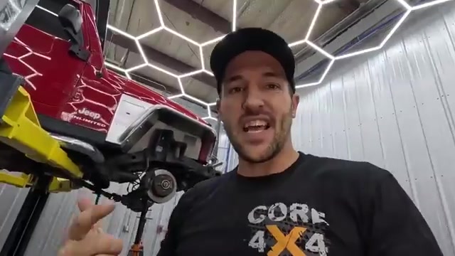 Spence explaining the front suspension components with the LJ on the lift behind him