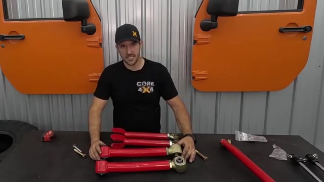 Spence at the workbench with red Core 4x4 Camp Series control arms laid out alongside the LJ doors