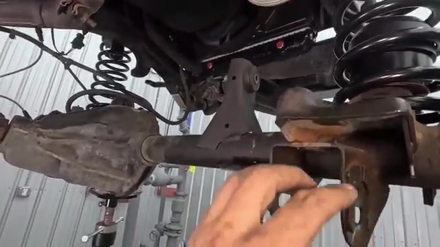 Underside view of the LJ front axle with new coil spring and control arm mounting area