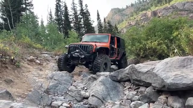 Red RAM truck on a BendPak lift in the Core 4x4 shop during a suspension install