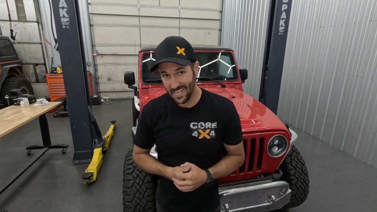 Rear suspension teardown in progress on the LJ Wrangler showing factory control arms and track bar