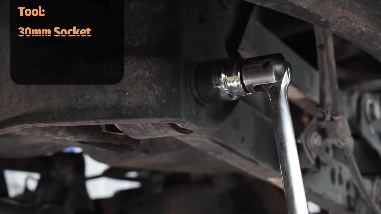 Removing factory control arm bolt with 30mm socket under the Ram 2500 rear axle