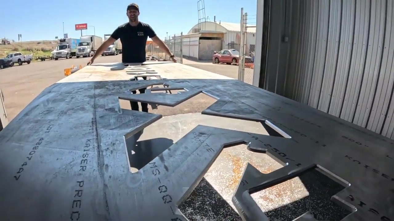 The raw aluminum tabletop outdoors with the Core 4x4 logo cut into it, ready for sanding and polishing