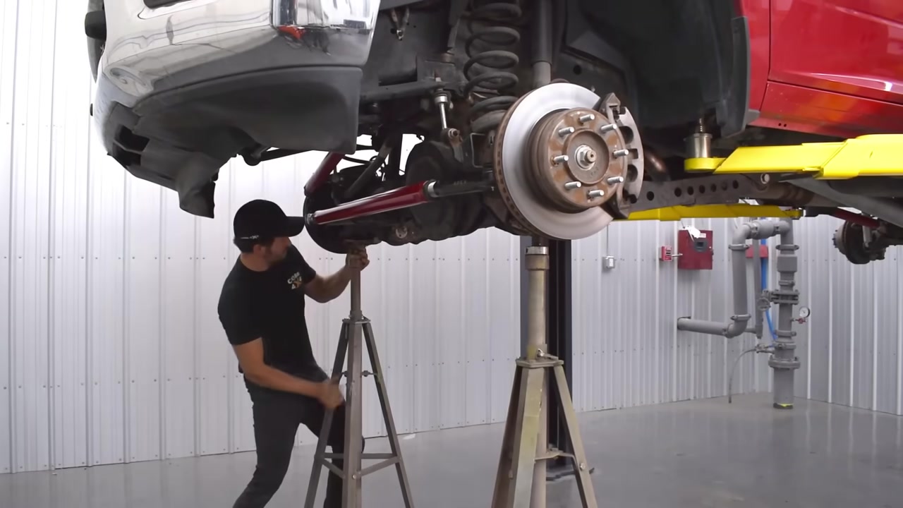 Positioning jack stands under the Ram 2500 front axle in preparation for suspension teardown