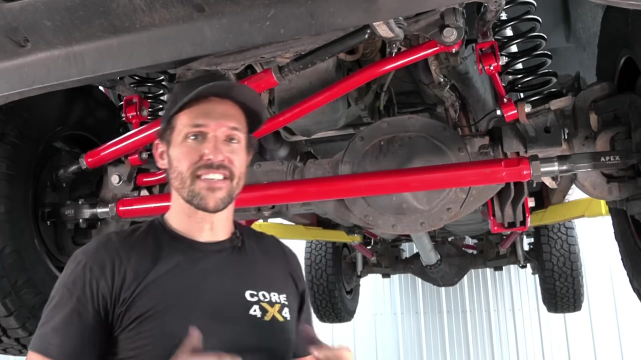 Completed Core 4x4 front suspension installed on the Ram 2500 viewed from below showing red radius arms, track bar, and end links