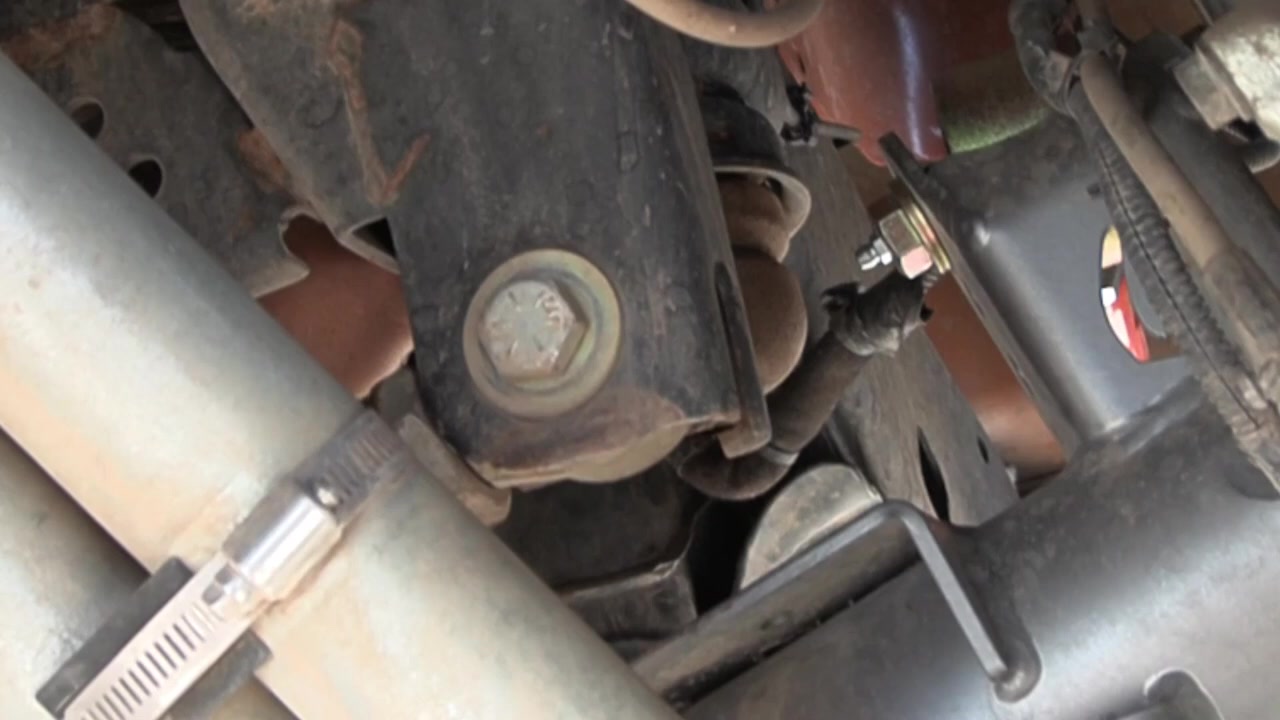 Underside view of the Jeep JK suspension showing the factory bump stop mount on the axle