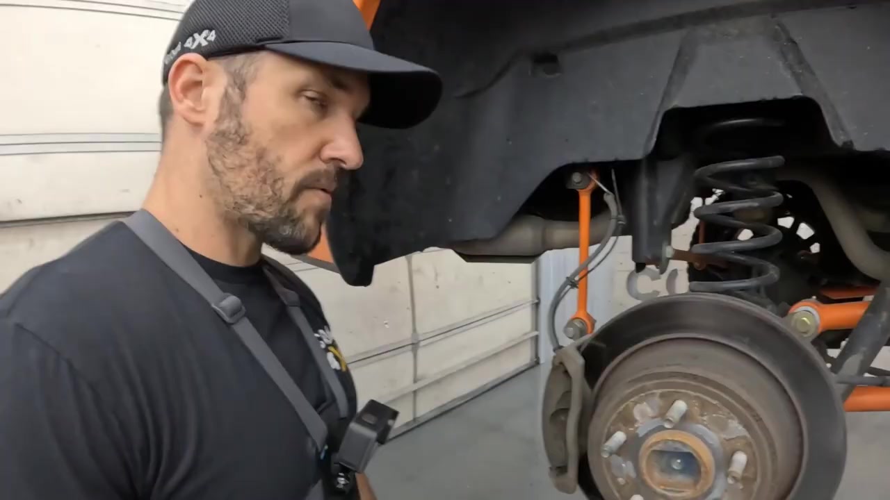 Rear brake caliper removed and rotor exposed on the Ram 1500 with Core 4x4 suspension visible