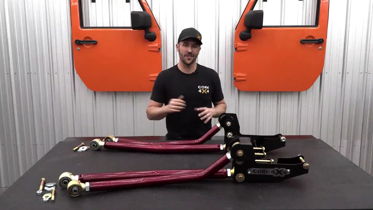 Spence at the Core 4x4 shop table with the new Ram 3500 long arm kit including control arms, brackets, and hardware in Illusion Cherry powder coat