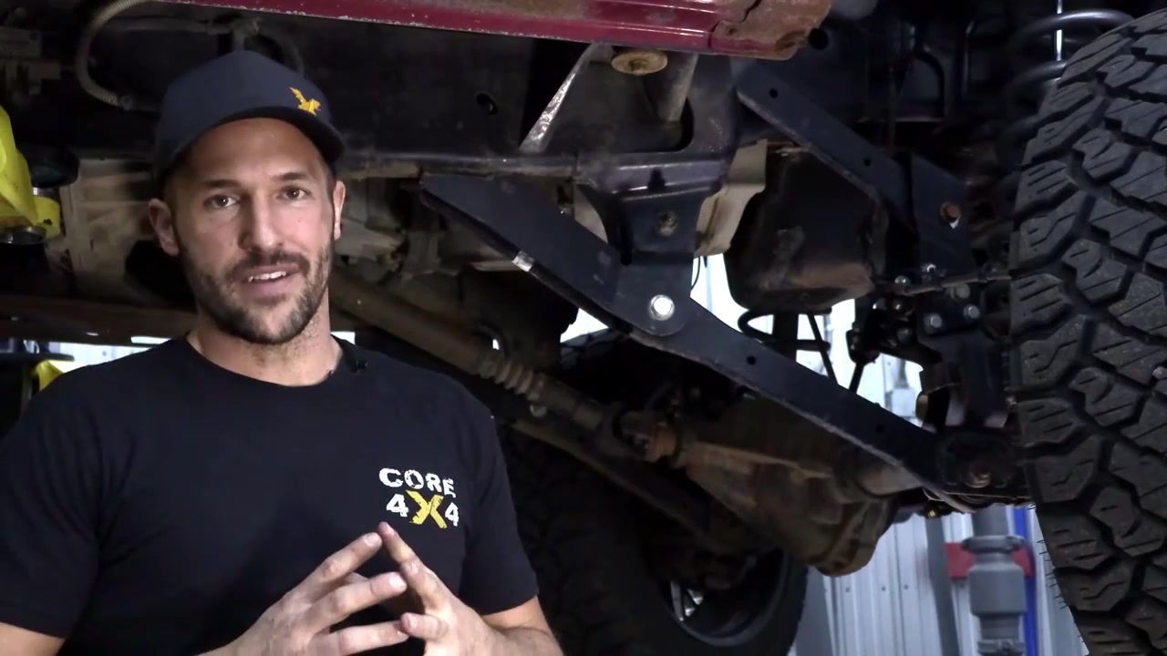Spence explaining the long arm kit under the Ram 3500, showing the existing steering and suspension upgrades