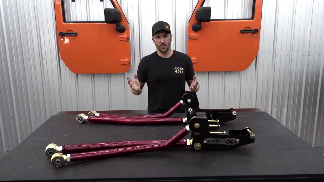 Close-up of the Core 4x4 long arm kit components on the shop table showing brackets, Johnny Joints, and Illusion Cherry powder-coated control arms
