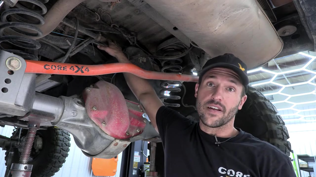 Spence underneath JK Wrangler showing axle and undercarriage before gas tank removal