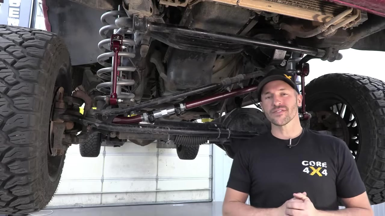 Spence at Core 4x4 under the lifted Ram 3500 showing existing front steering and suspension