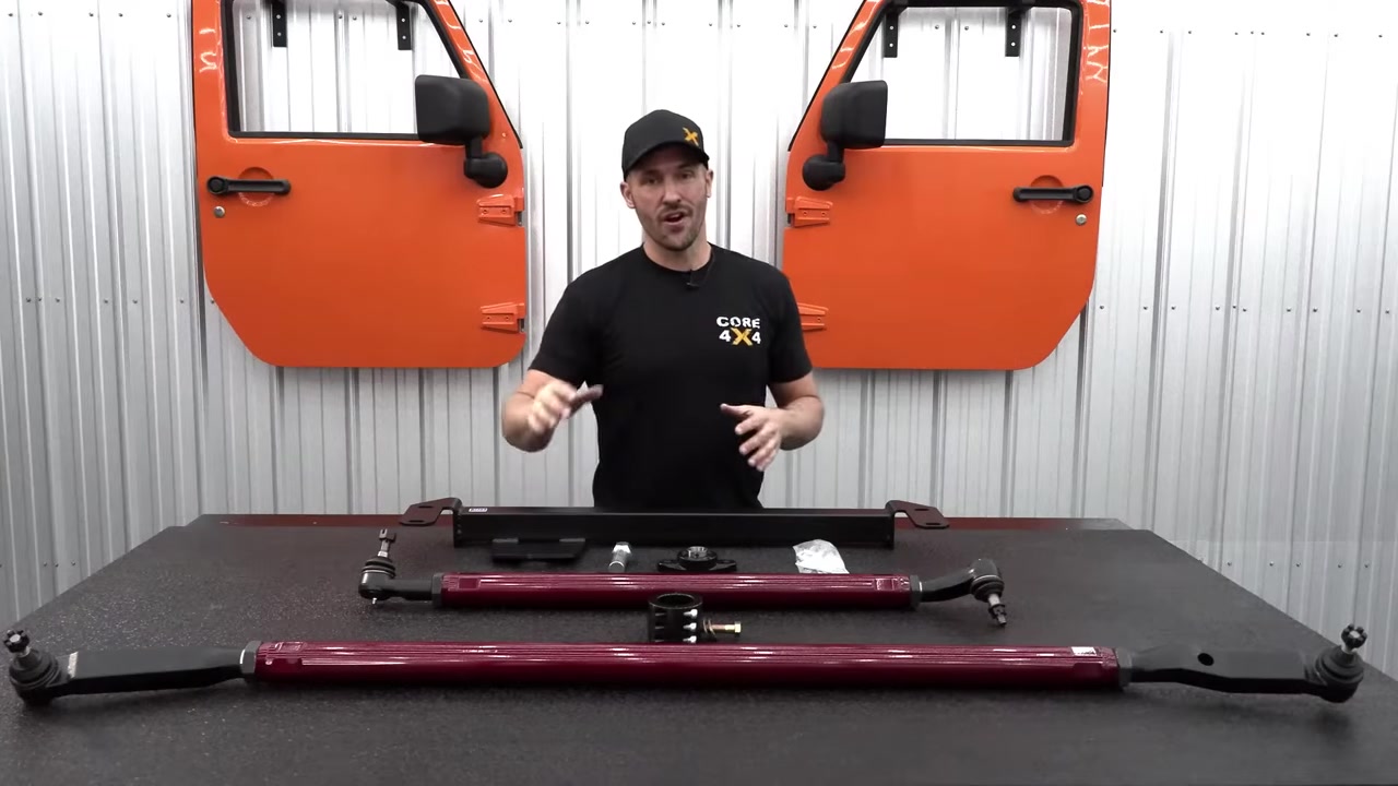 Core 4x4 2.5 ton steering kit for Ram 3500 laid out on the shop table: red aluminum tie rod, drag link, steering box brace, and hardware