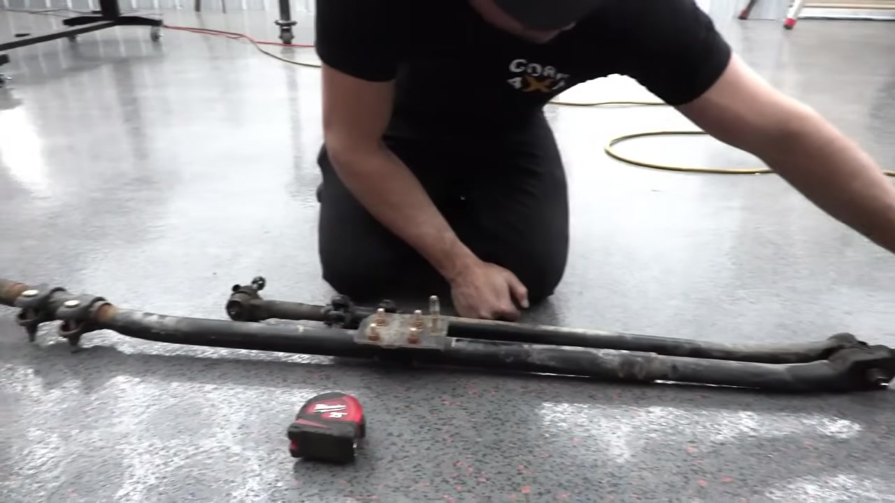 Measuring the factory tie rod center to center on the shop floor before installing the Core 4x4 replacement