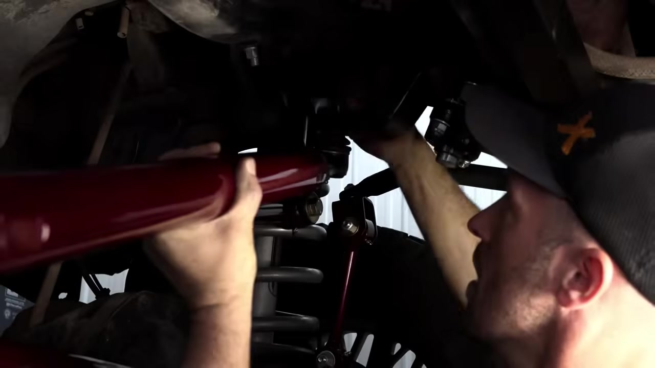 Positioning the new Core 4x4 drag link on the Ram 3500 with the red aluminum tube visible