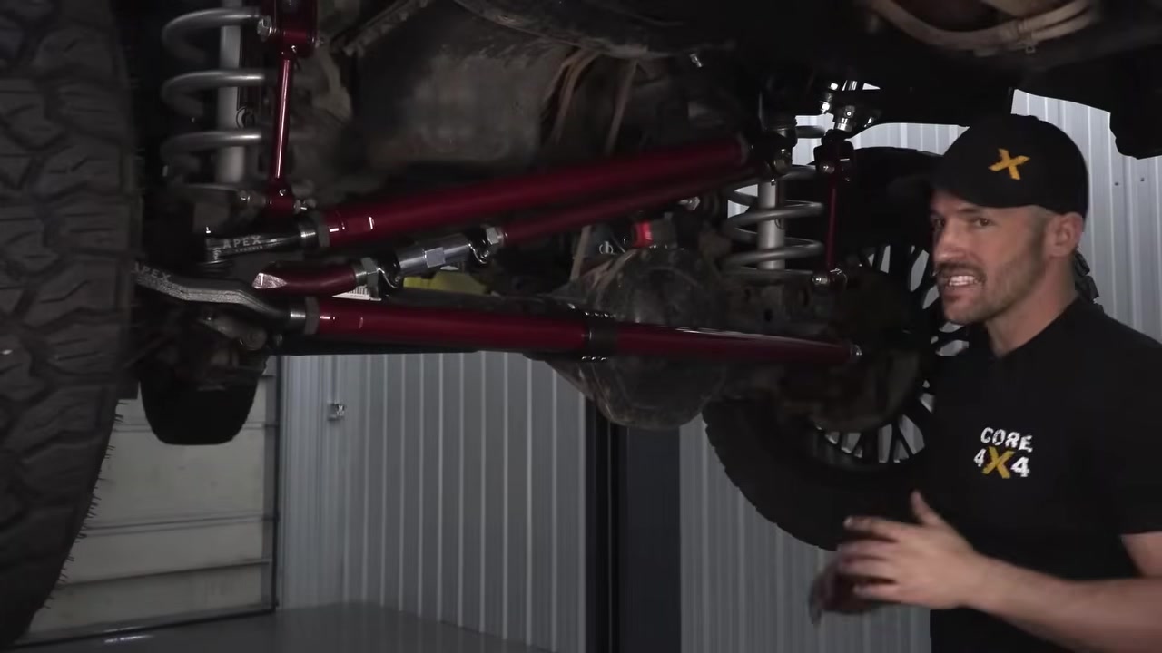 Spence presenting the completed Core 4x4 steering upgrade on the Ram 3500 with red aluminum tie rod and drag link installed