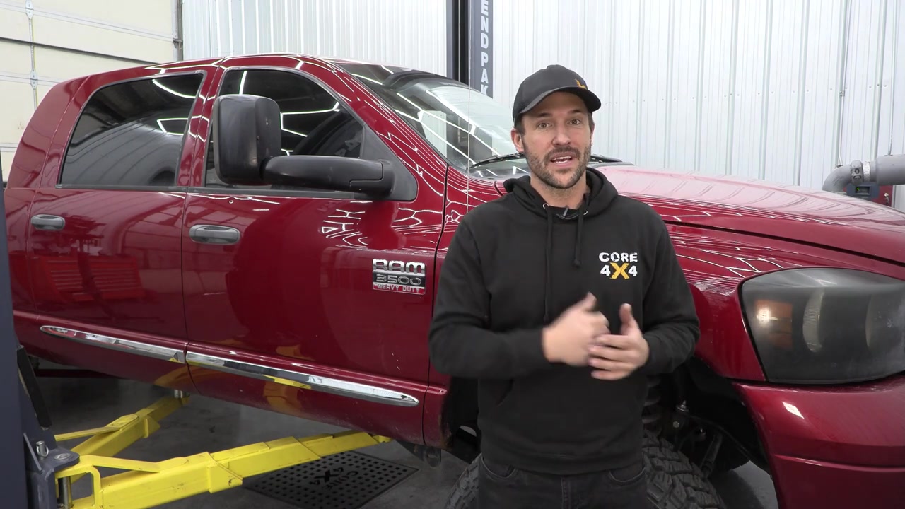 Spence from Core 4x4 standing next to a red 2008 Ram 3500 in the shop