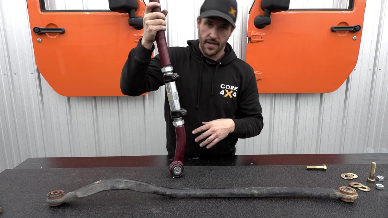 Core 4x4 track bar held up next to old factory track bar showing the size and build quality difference