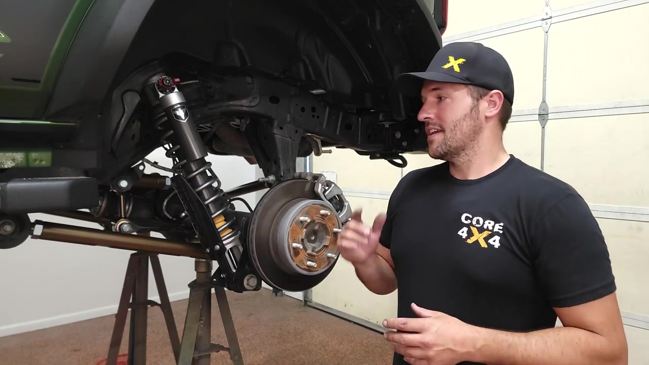 Spence from Core 4x4 standing next to the green 2022 Ford Bronco with the completed rear sway bar end link install, showing the new Crawl Series end links in the rear suspension