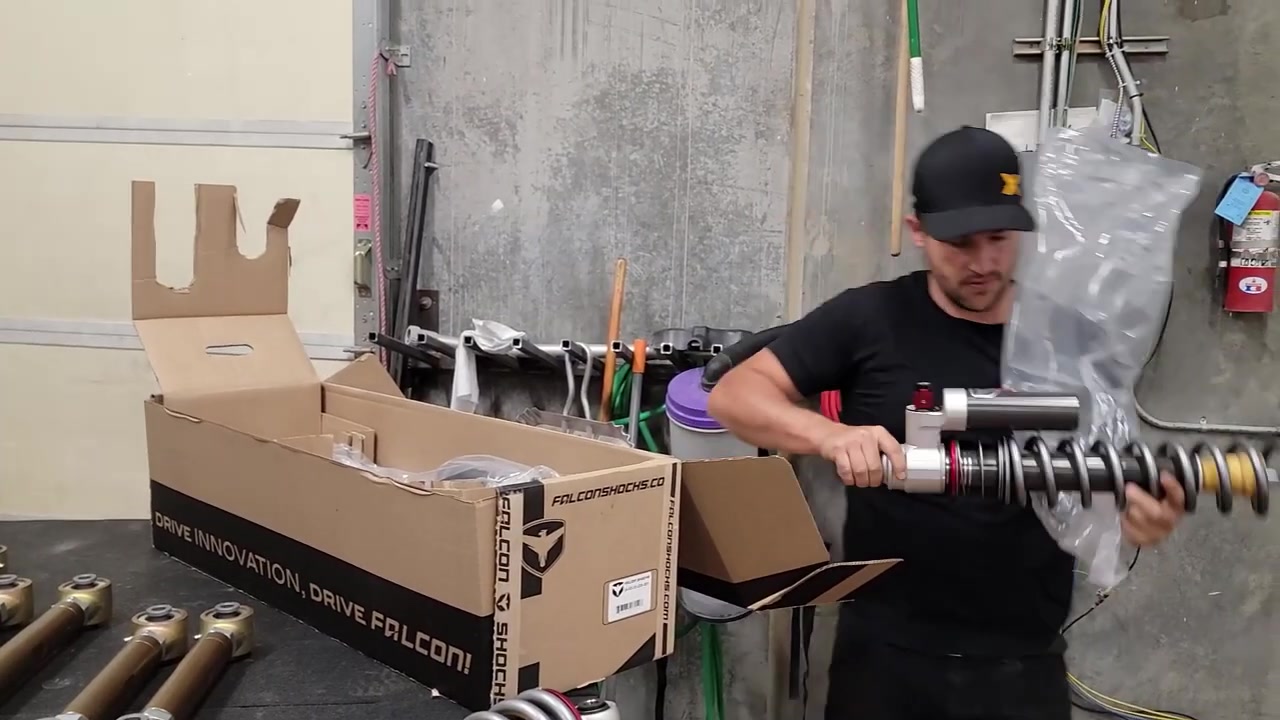 Spence from Core 4x4 unboxing Falcon 3.5 inch coilovers with bronze powder-coated control arms on the workbench