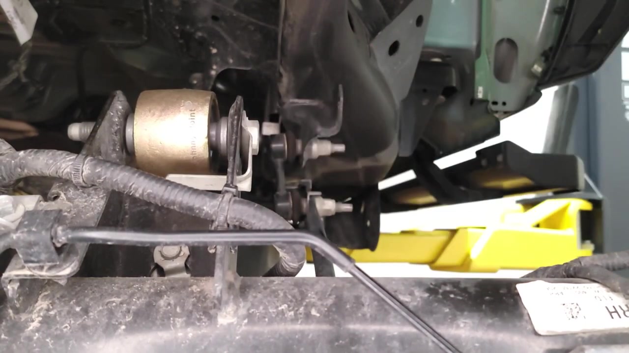 Bronze powder-coated Johnny Joint installed on the passenger side rear axle bracket of the Ford Bronco on the lift