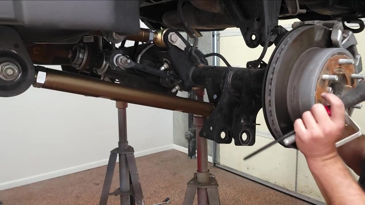 Bronze Core 4x4 lower control arm installed on the driver side rear of the Ford Bronco with axle on jack stands