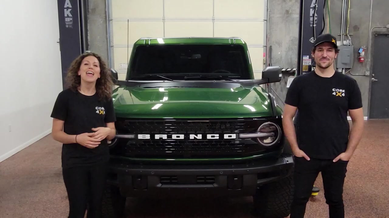 Spence and Marissa from Core 4x4 standing in front of the Eruption Green 2022 Ford Bronco in the shop