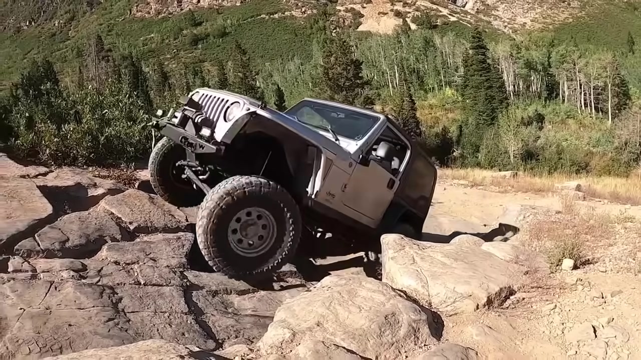Jeep Wrangler rock crawling over boulders on a mountain trail equipped with Core 4x4 suspension