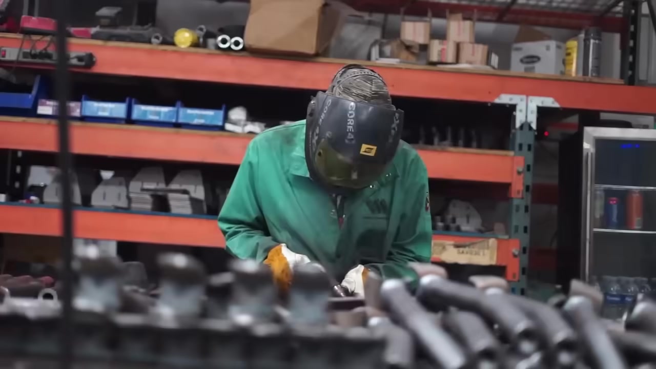 Core 4x4 team member welding a control arm in the manufacturing facility wearing a Core 4x4 branded welding helmet