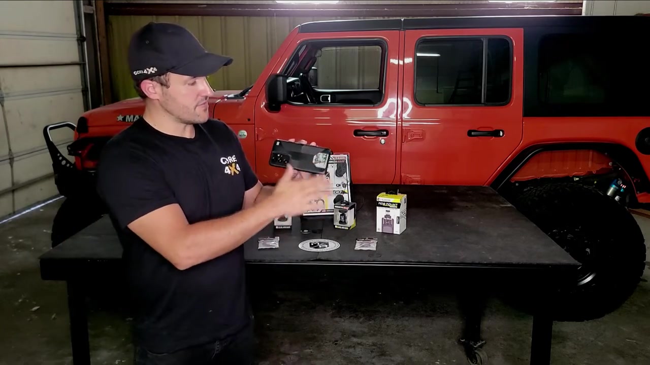 Spence from Core 4x4 presenting Mob Armor phone mount products in front of red Jeep Wrangler JL