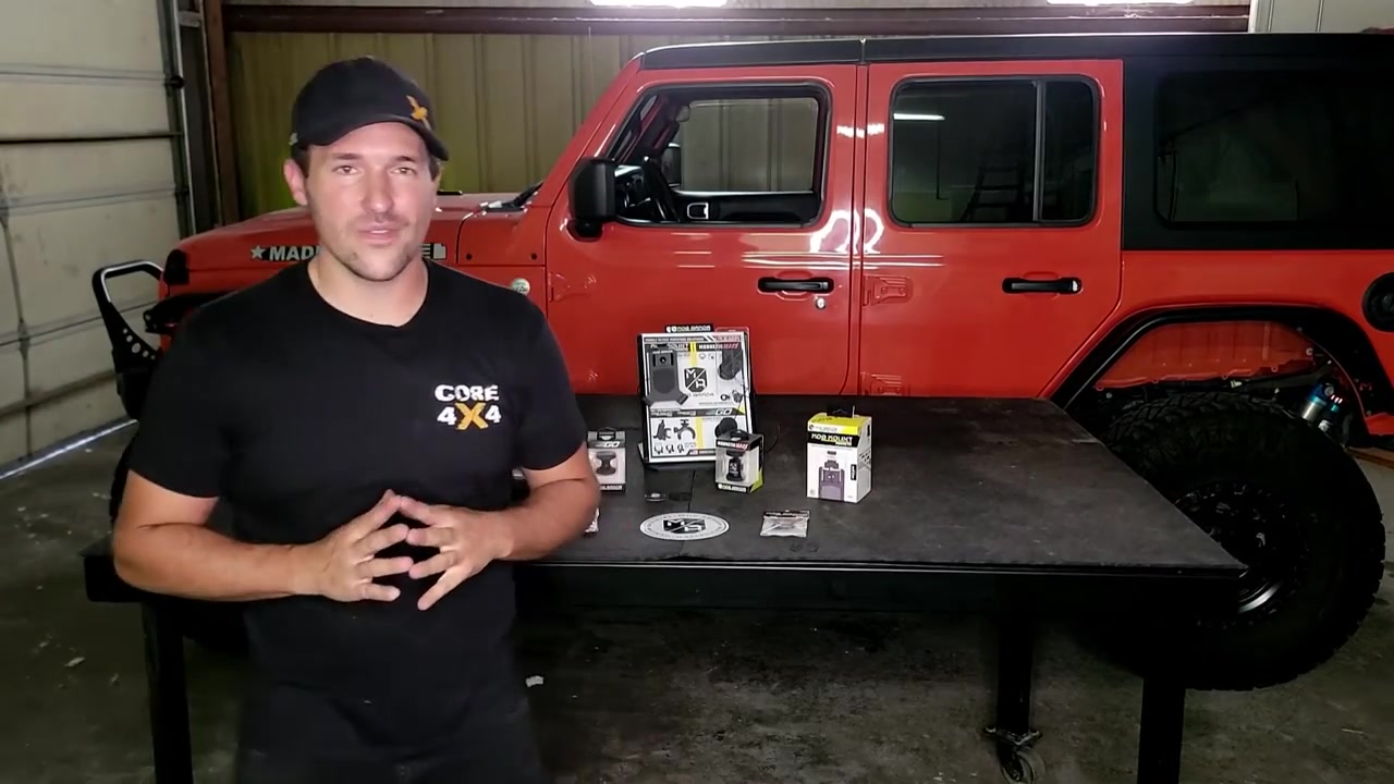 Spence from Core 4x4 wrapping up Mob Armor phone mount install video with red Jeep Wrangler JL in background