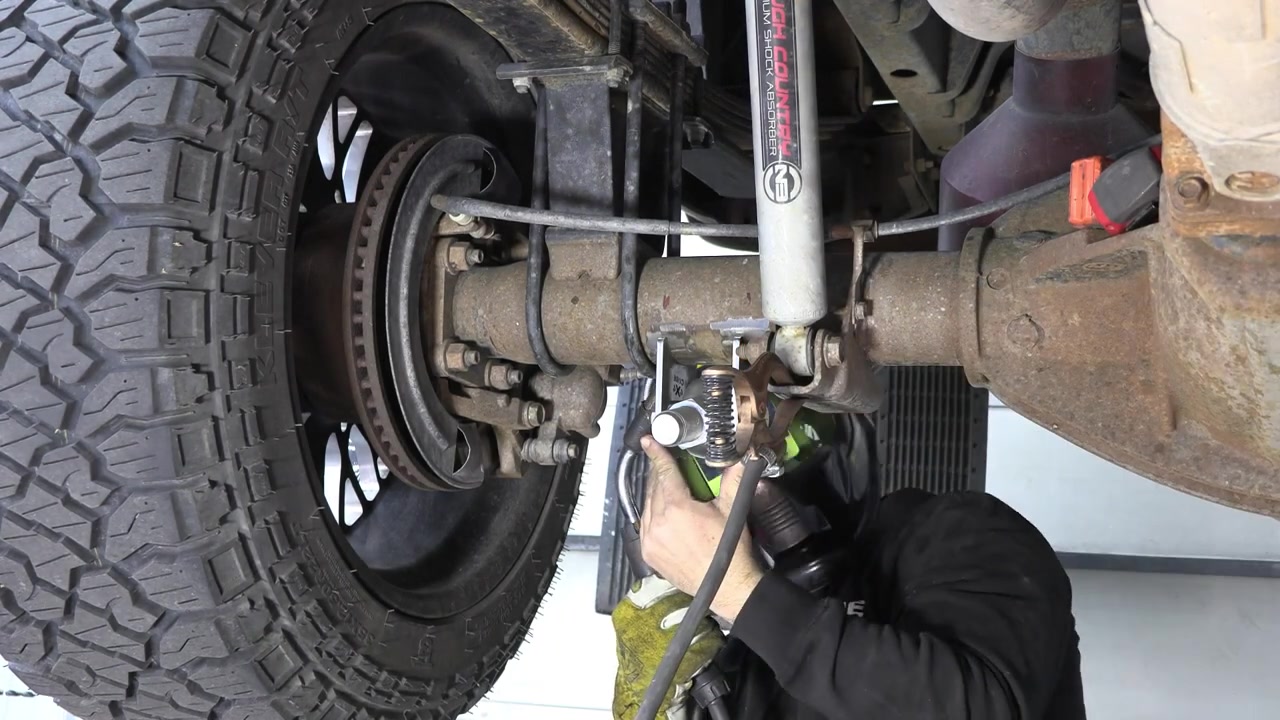 Close-up of the welded axle bracket on the Ram 3500 rear axle showing the stitch weld pattern and bracket positioning