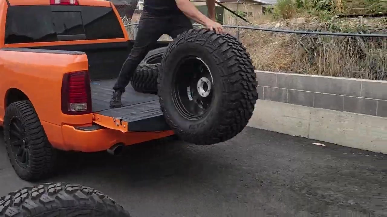 Unloading new Kanati Mud Hog tires from the truck bed at the Core 4x4 shop